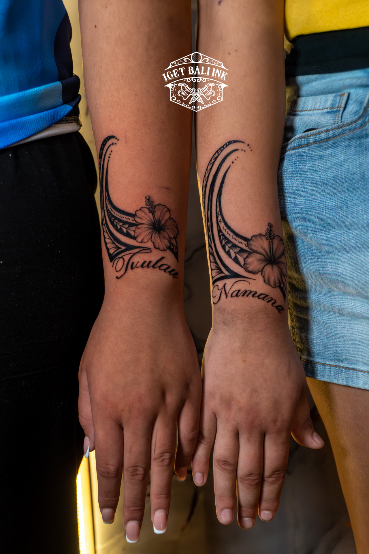 Matching Polynesian tribal and hibiscus forearm tattoos with names