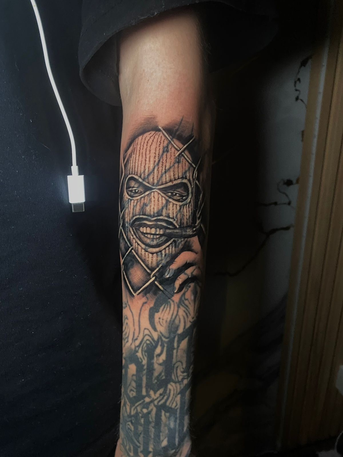Chicano balaclava man with cigar forearm tattoo
