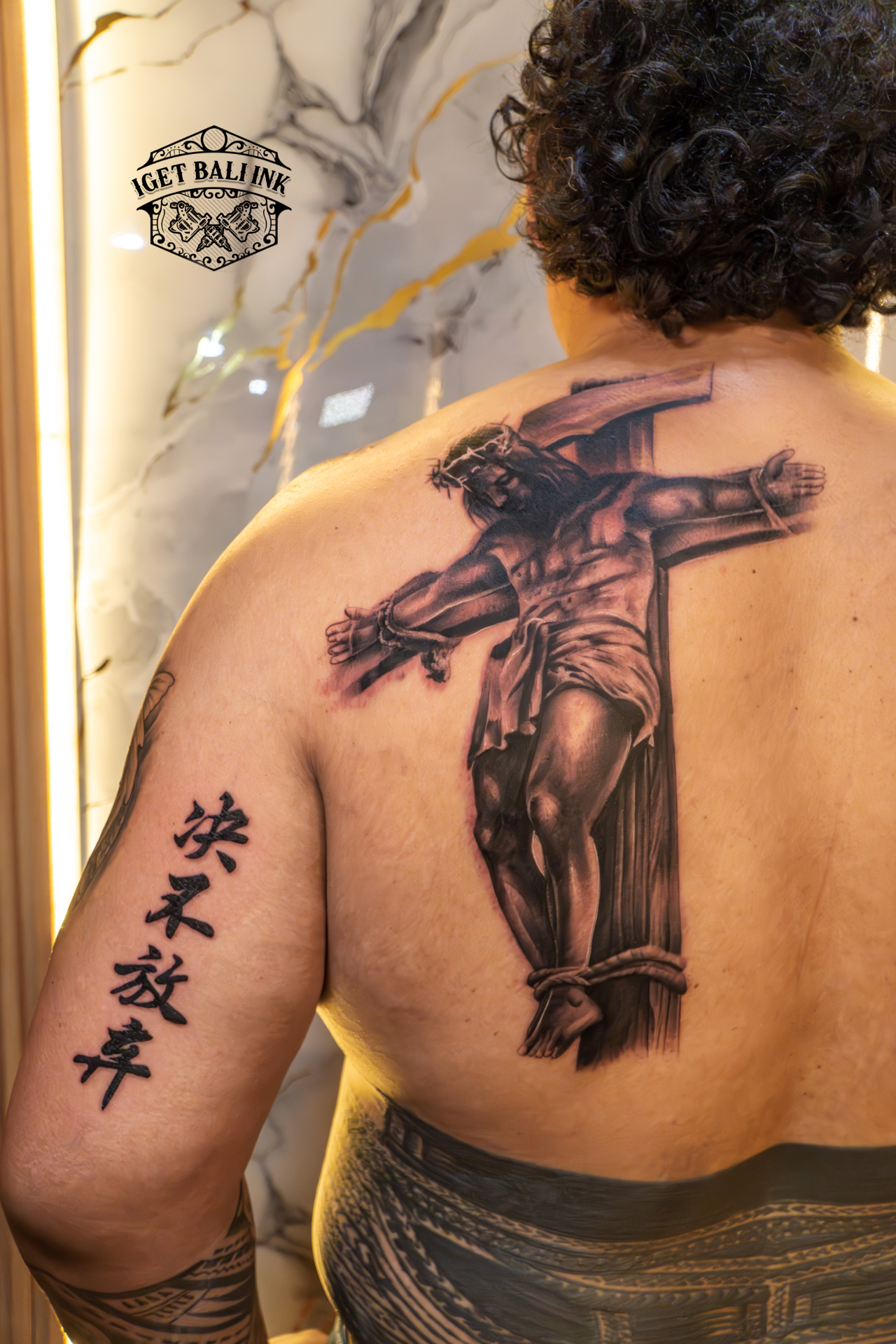 Realistic crucifixion back piece with kanji lettering on the arm