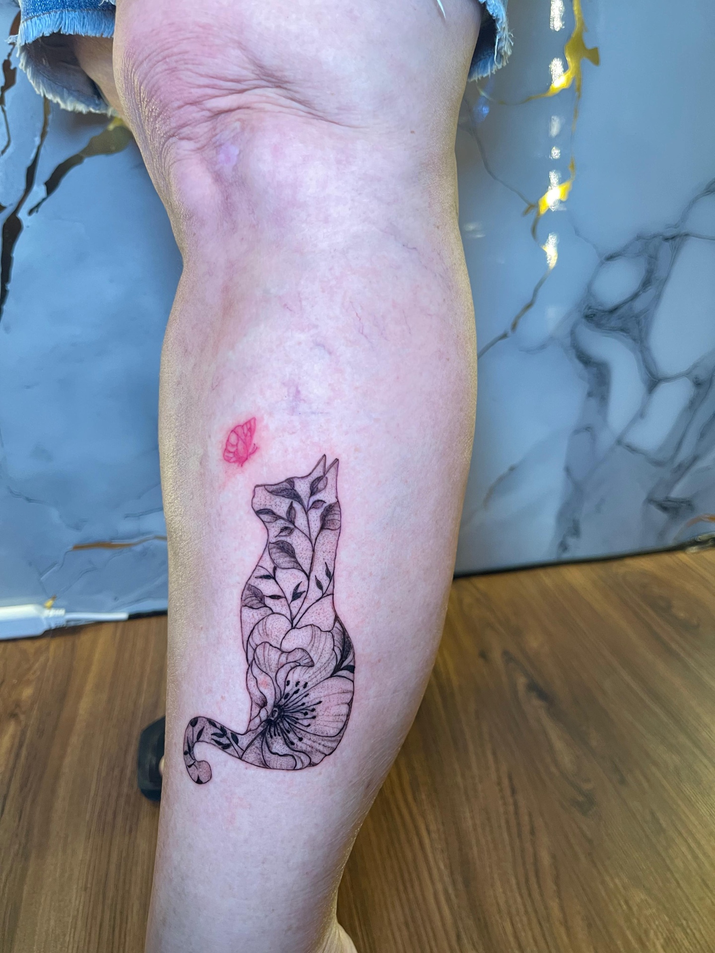Fine line floral cat silhouette with red butterfly on the calf