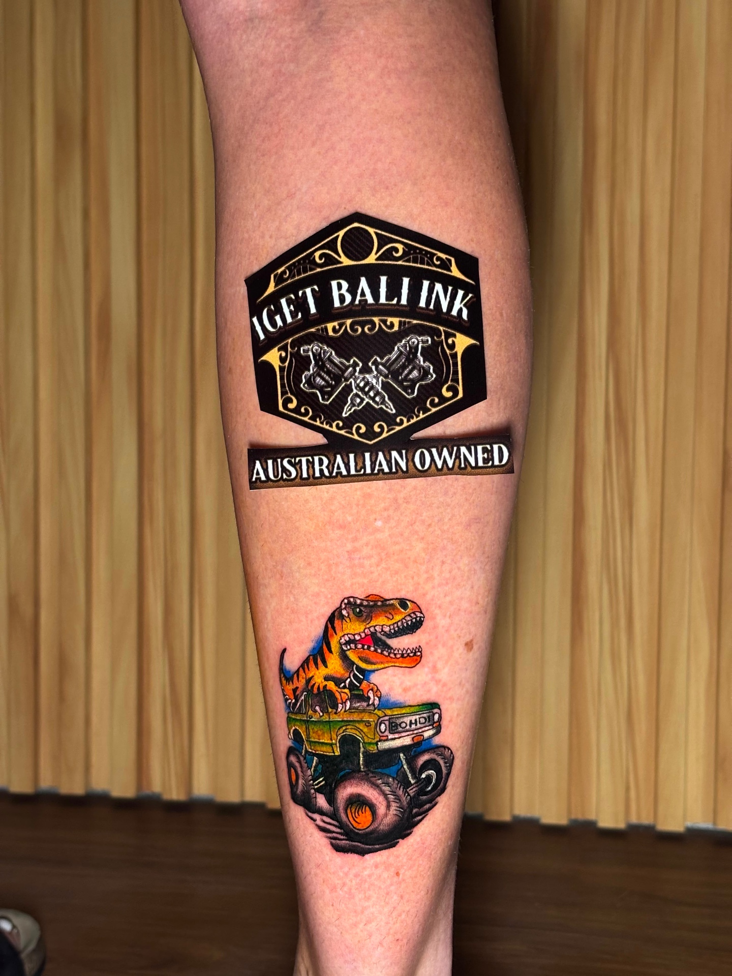 Colour neo-traditional T-rex monster truck calf tattoo