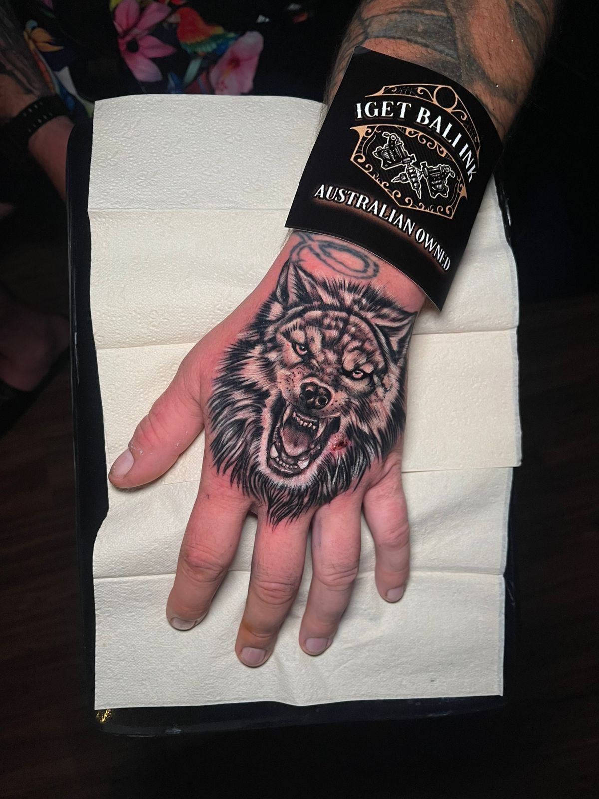 Realistic snarling wolf hand tattoo in black and grey