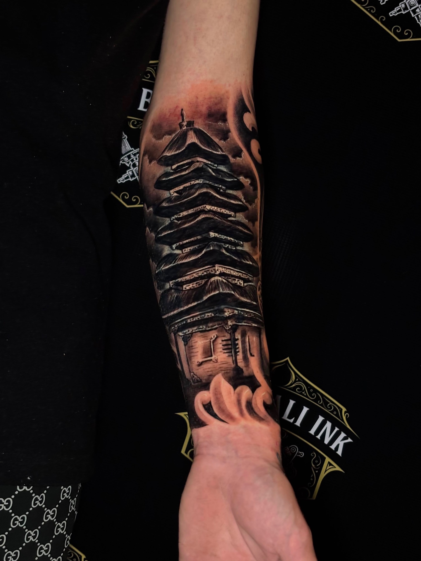 Balinese temple forearm tattoo in black and grey