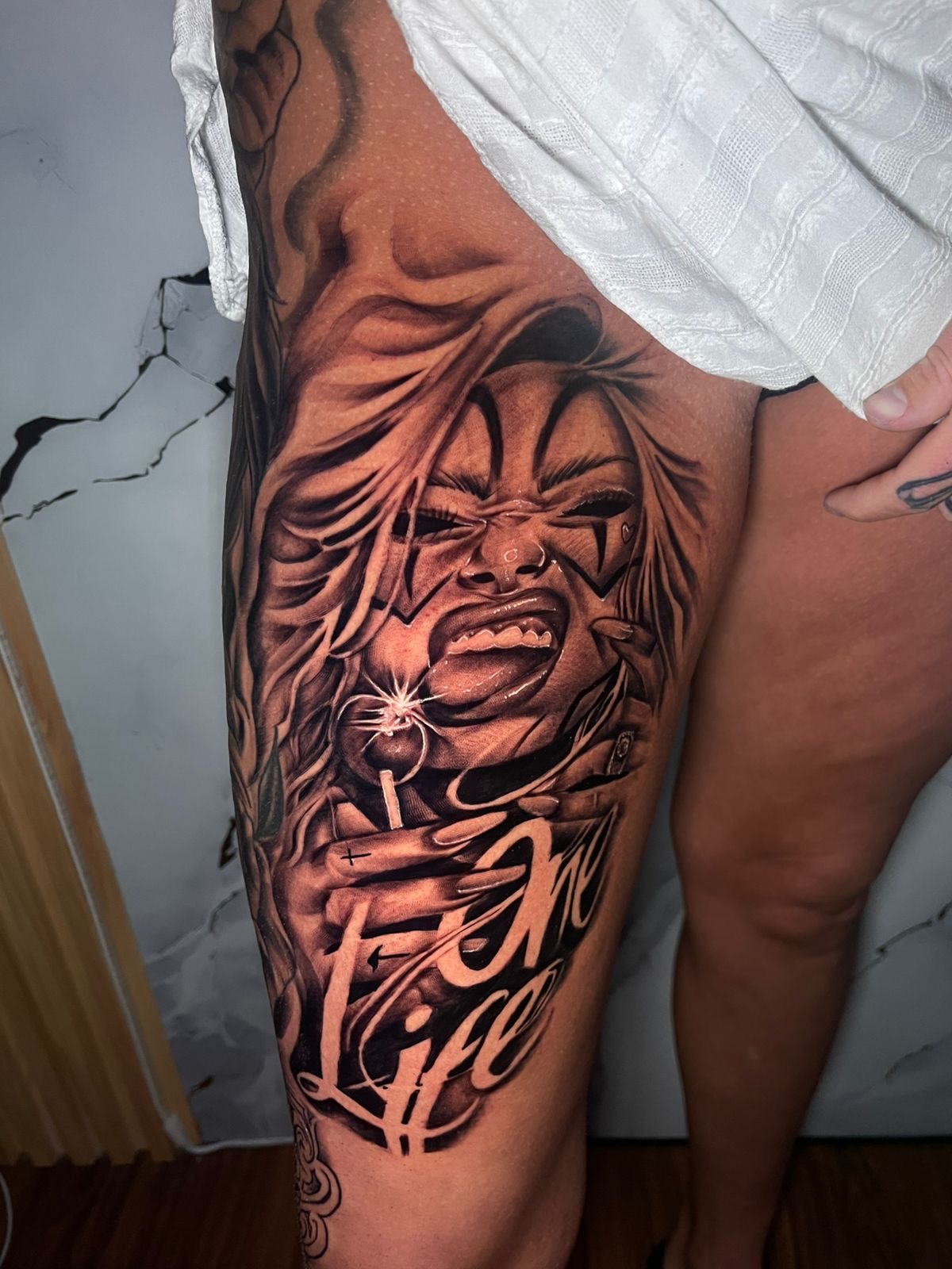 Chicano laughing clown girl thigh tattoo