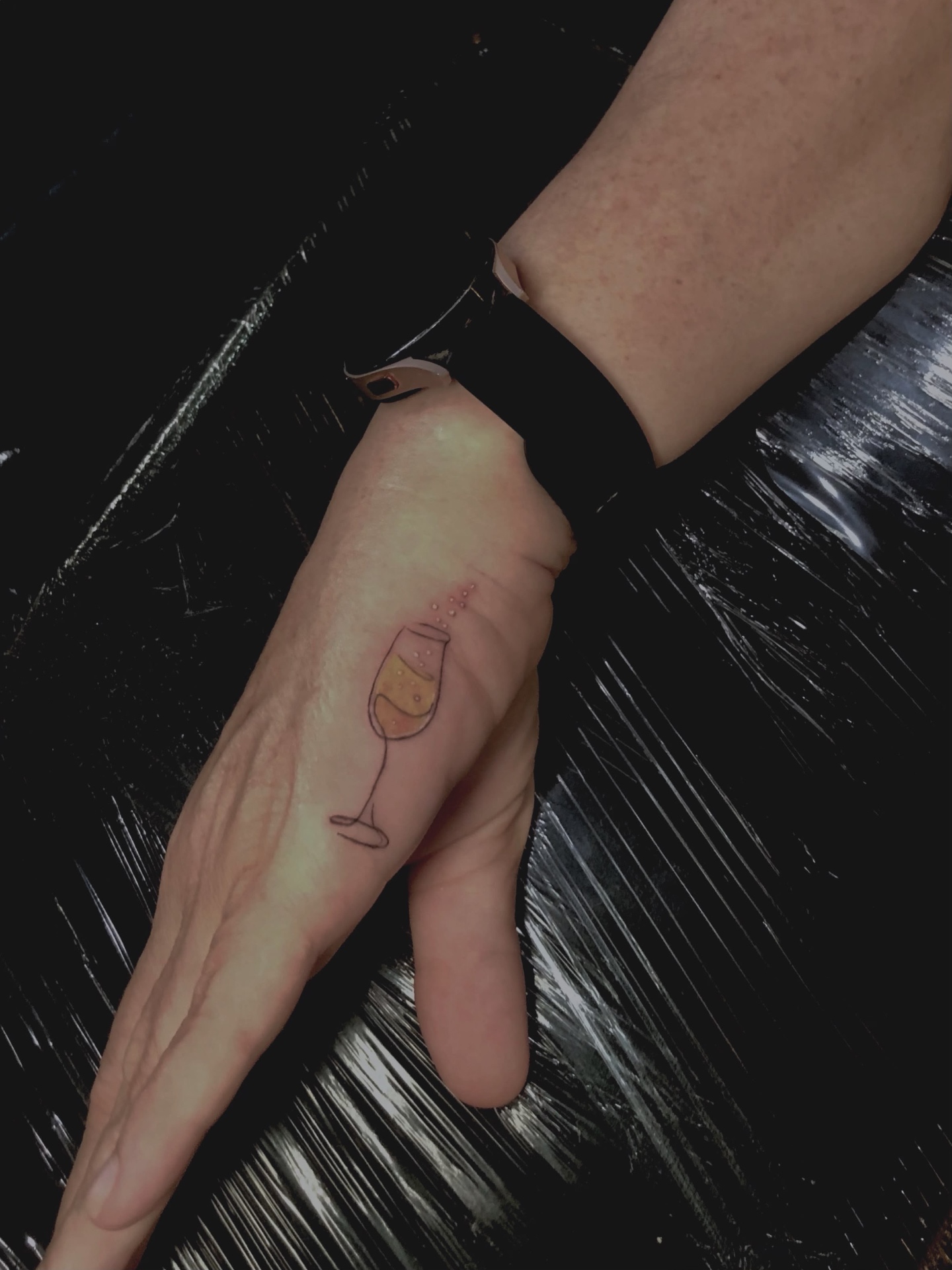 Fine line champagne glass tattoo on the finger