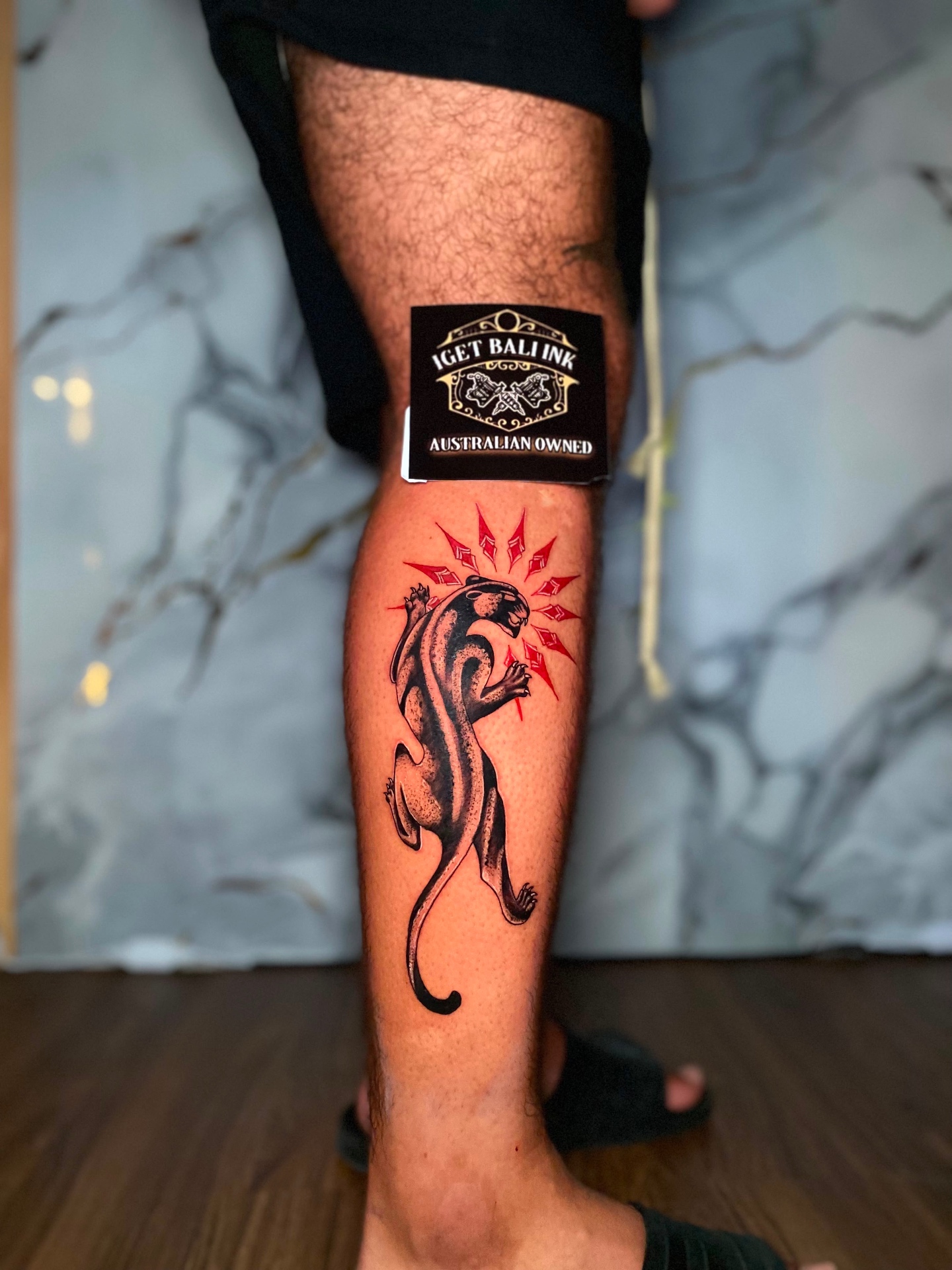 Traditional black panther with red rays on the calf