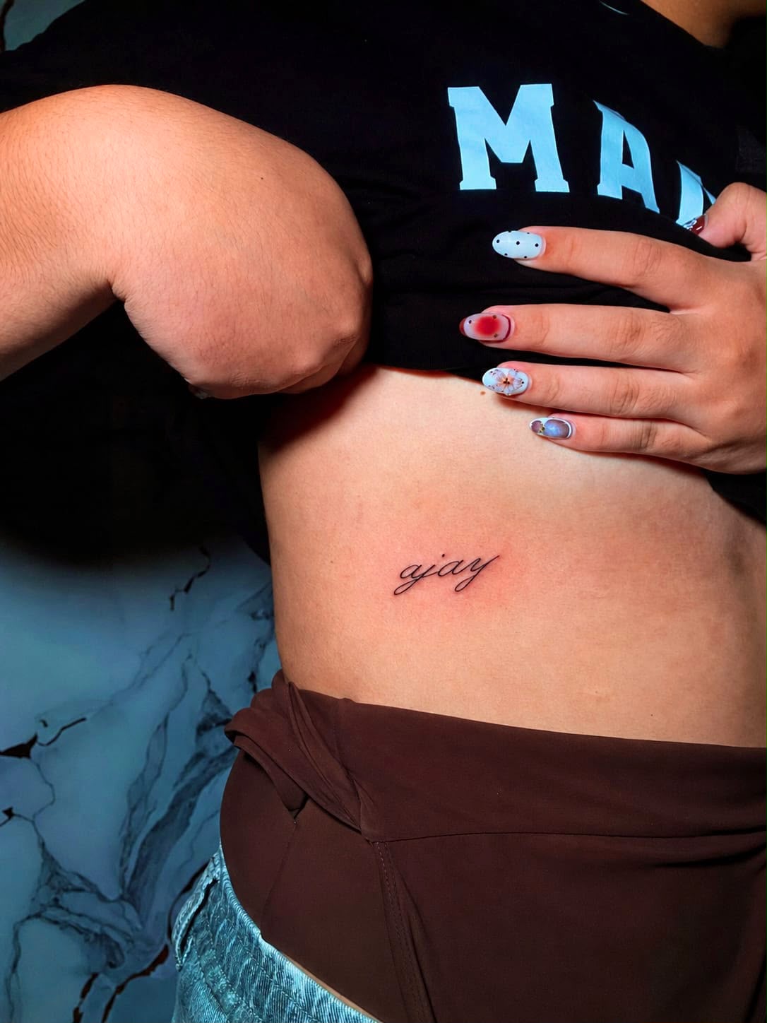 Fine line ajay script on the ribs