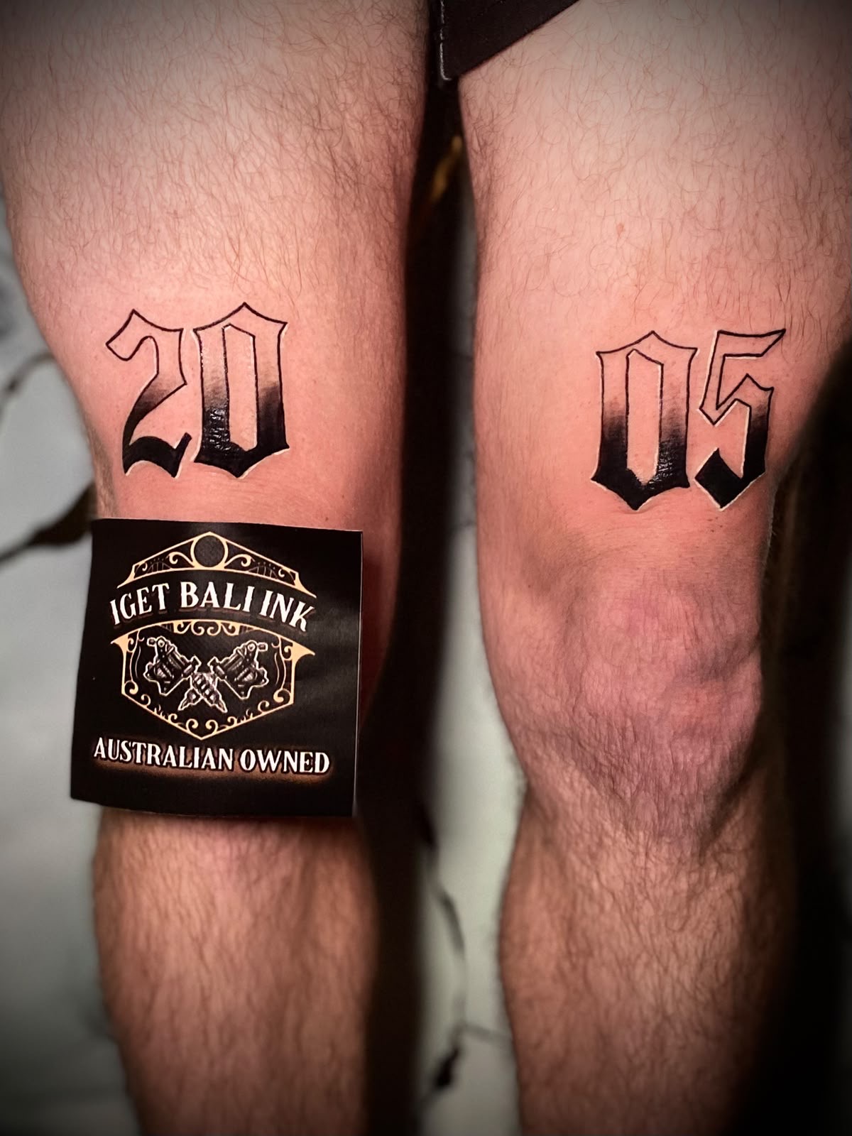 Gothic 2005 lettering split across both knees