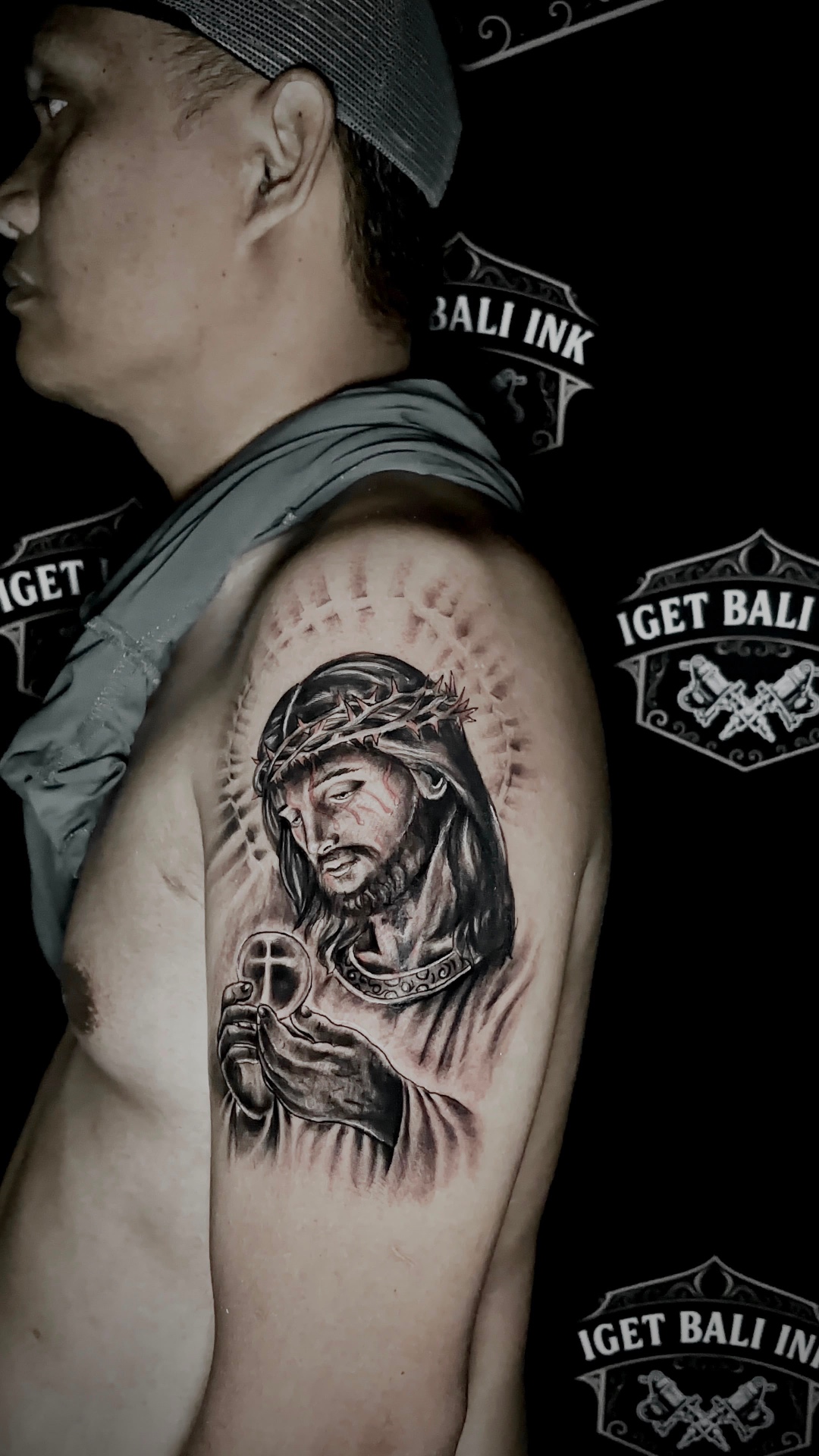 Black and grey religious portrait of Jesus on the upper arm