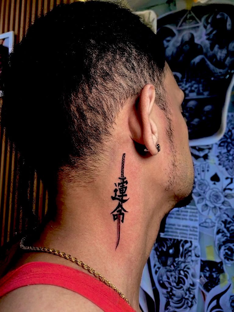 Japanese kanji brushstroke tattoo behind the ear